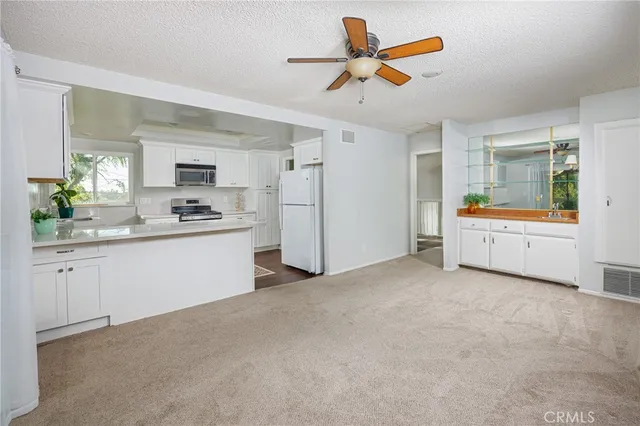 a view of a kitchen with a sink and a refrigerator