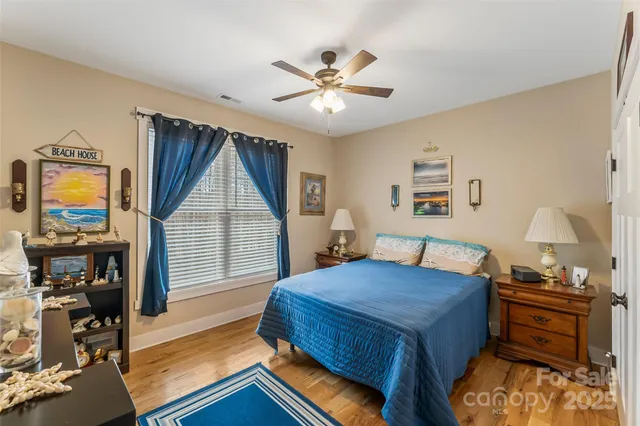 a view of a livingroom with wooden floor and a ceiling fan