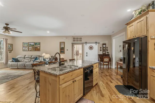 a spacious bathroom with stainless steel appliances a sink a mirror and a flat screen tv