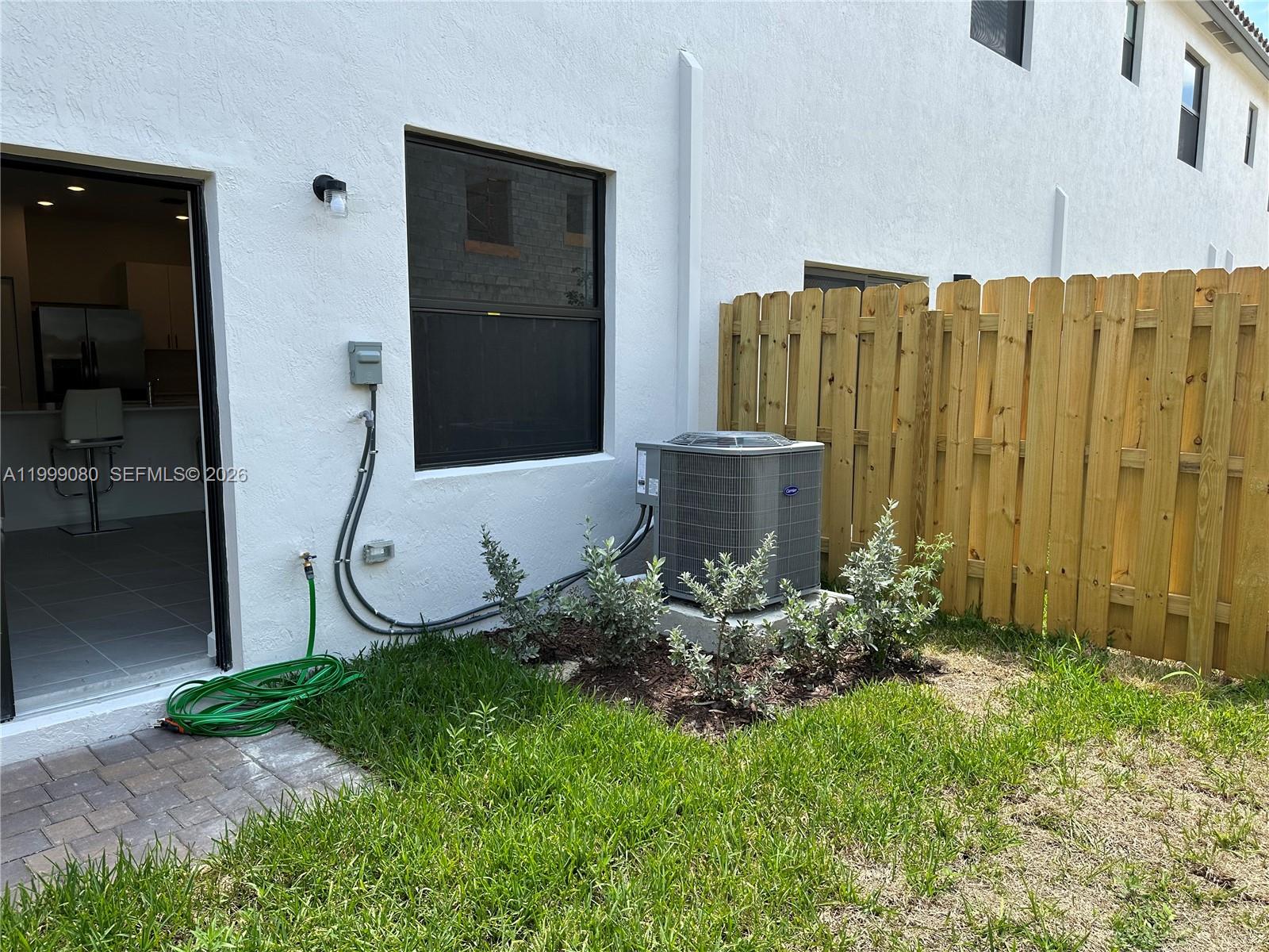 11767 Southwest 246th Terrace Homestead, FL 33032 - Photo 22 of 29 a view of a backyard with potted plants and wooden fence