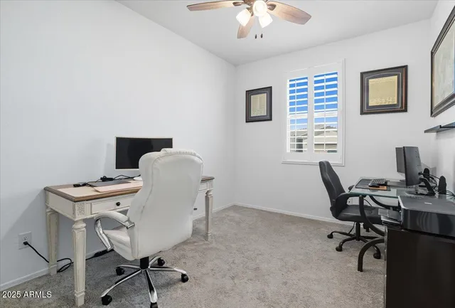 a view of a workspace with furniture and a window