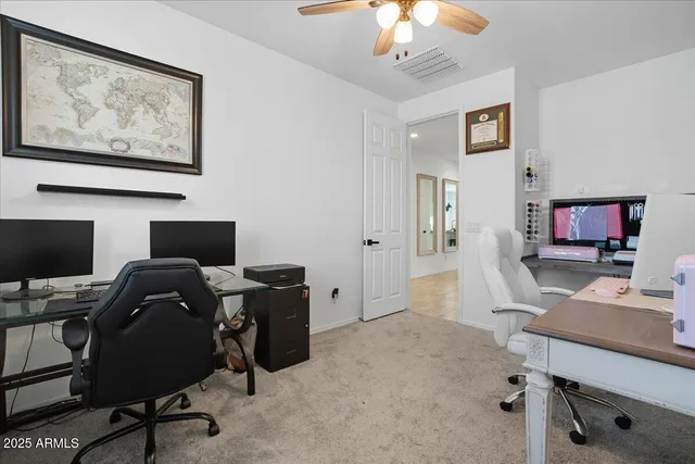 a view of a workspace with furniture and a window