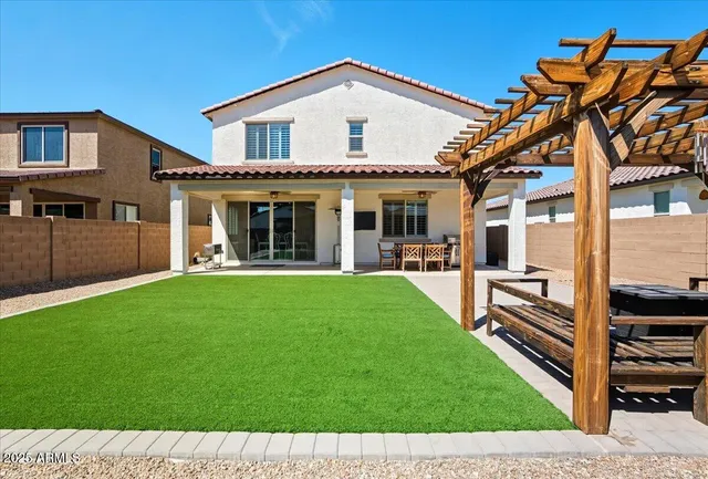a front view of a house with a yard and potted plants
