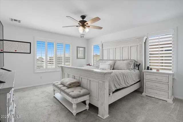 a spacious bedroom with a bed and a chandelier