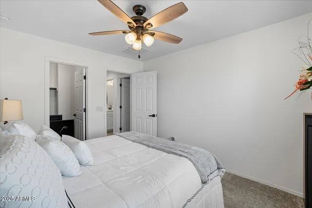 a bedroom with a large bed and a chandelier