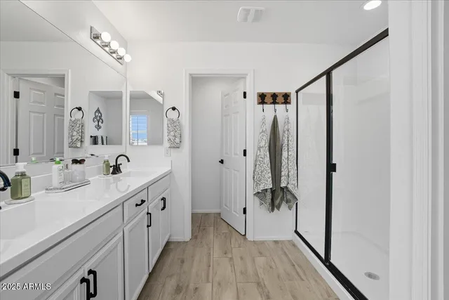 a spacious bathroom with a double vanity sink mirror and shower