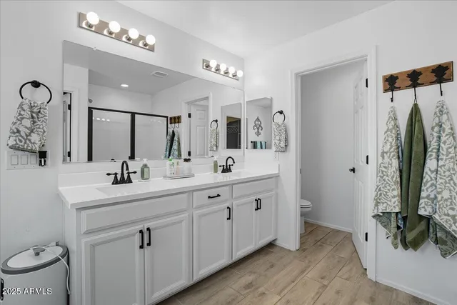 a bathroom with a double vanity sink mirror and toilet