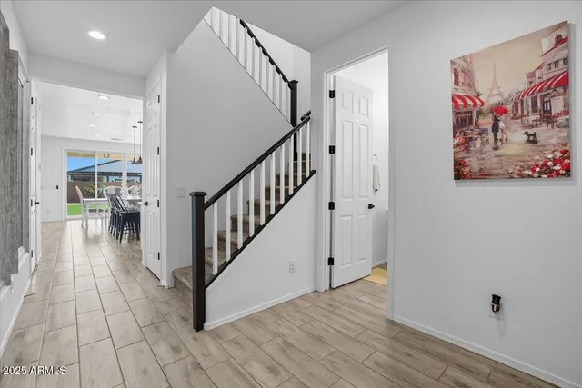 a view of a hallway with wooden floor and stairs