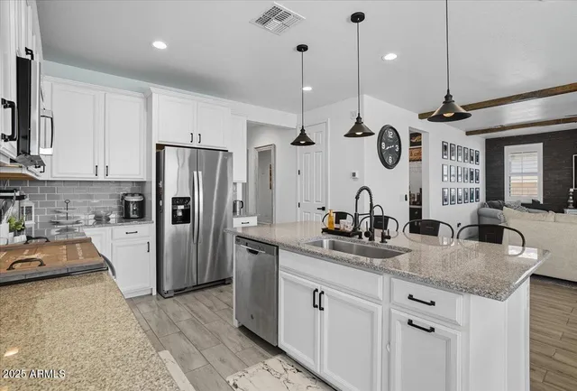 a kitchen with stainless steel appliances granite countertop a sink a stove and refrigerator