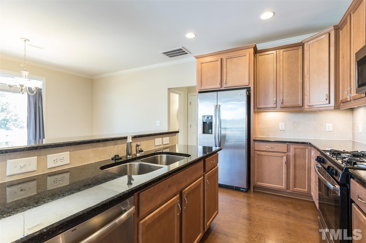 4244 Rockdell Hall Street Raleigh, NC 27616 - Photo 14 of 29 a kitchen with stainless steel appliances granite countertop a sink stove and refrigerator