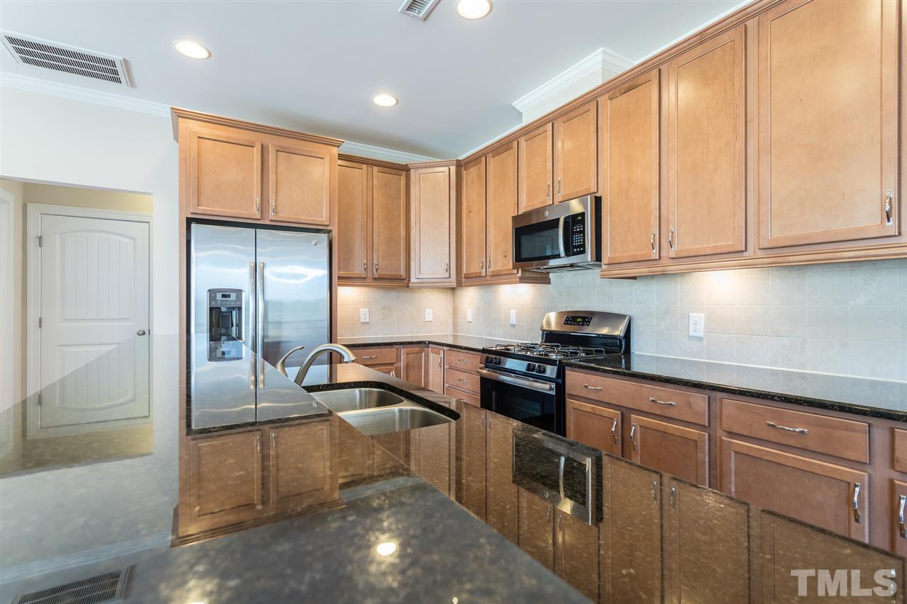 4244 Rockdell Hall Street Raleigh, NC 27616 - Photo 15 of 29 a kitchen with kitchen island granite countertop a sink stove and refrigerator