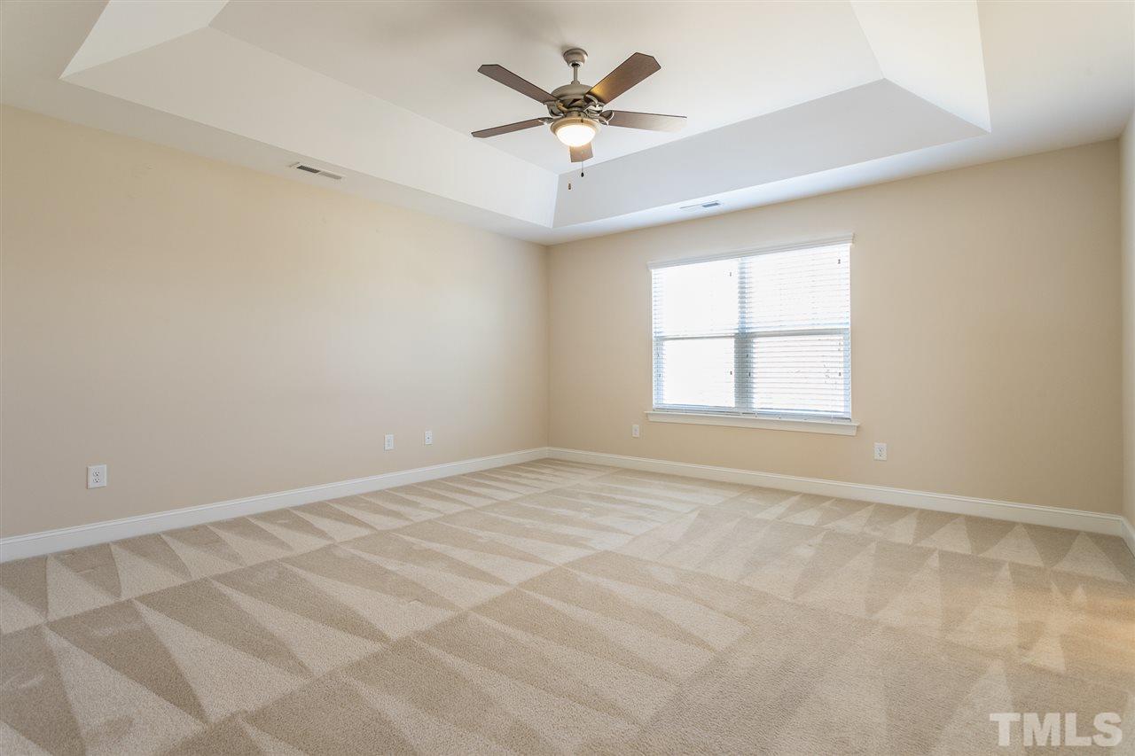 4244 Rockdell Hall Street Raleigh, NC 27616 - Photo 25 of 29 an empty room with chandelier fan and windows