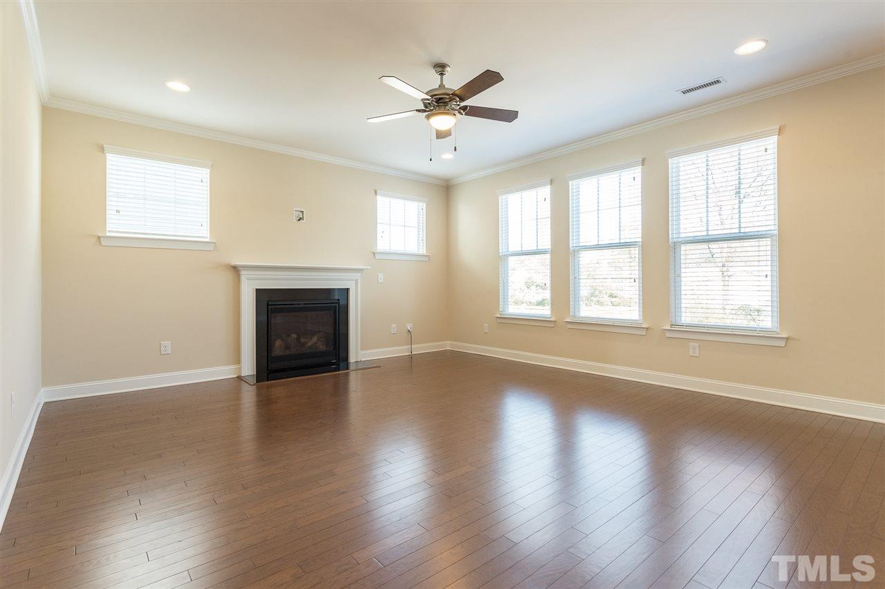 4244 Rockdell Hall Street Raleigh, NC 27616 - Photo 6 of 29 an empty room with wooden floor fan and windows