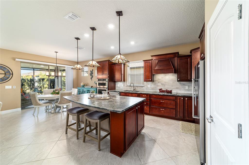 6382 Southwest 97th Terrace Road Ocala, FL 34481 - Photo 11 of 56 a kitchen with stainless steel appliances granite countertop wooden cabinets a granite counter tops a stove a sink and a refrigerator