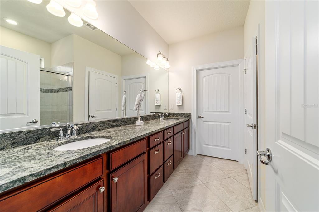 6382 Southwest 97th Terrace Road Ocala, FL 34481 - Photo 23 of 56 a bathroom with a granite countertop double vanity sink and a mirror