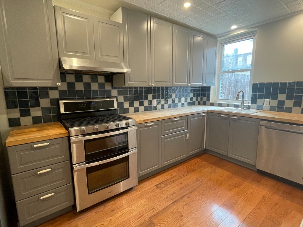 682 East 42nd Street, Unit 1 Brooklyn, NY 11203 - Photo 2 of 11 a kitchen with a stove a sink and a refrigerator