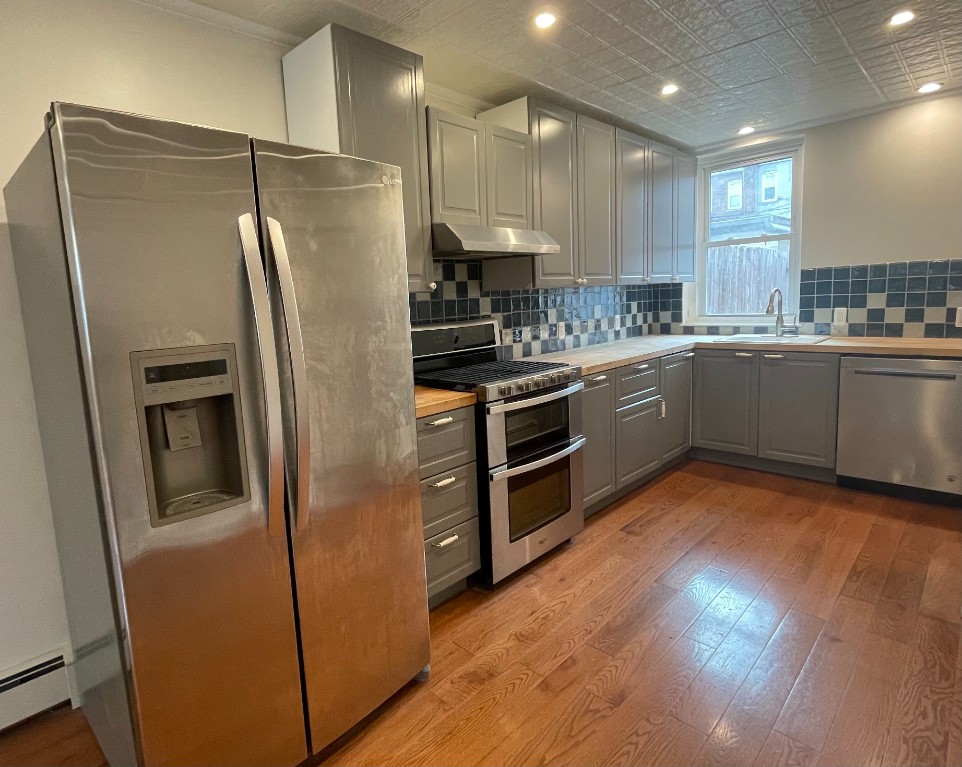 682 East 42nd Street, Unit 1 Brooklyn, NY 11203 - Photo 3 of 11 a kitchen with granite countertop stainless steel appliances a refrigerator a sink and cabinets