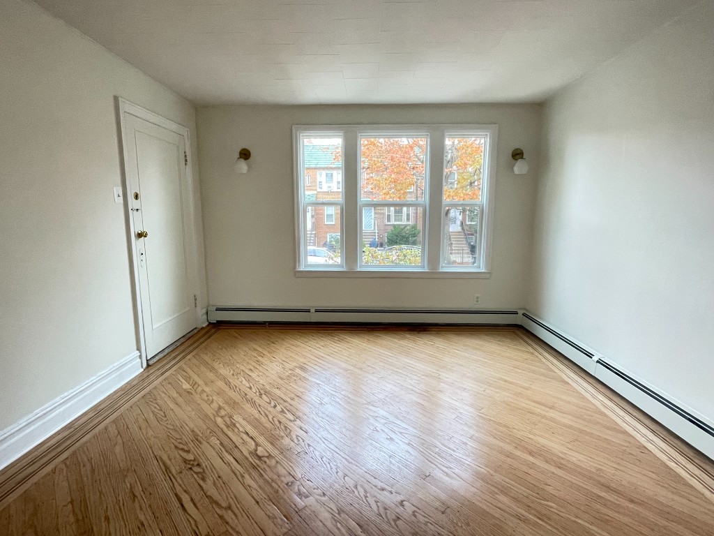 682 East 42nd Street, Unit 1 Brooklyn, NY 11203 - Photo 4 of 11 an empty room with wooden floor and windows