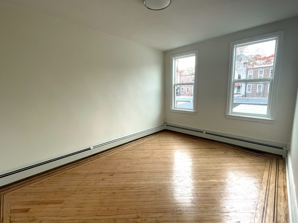 682 East 42nd Street, Unit 1 Brooklyn, NY 11203 - Photo 5 of 11 an empty room with wooden floor and windows