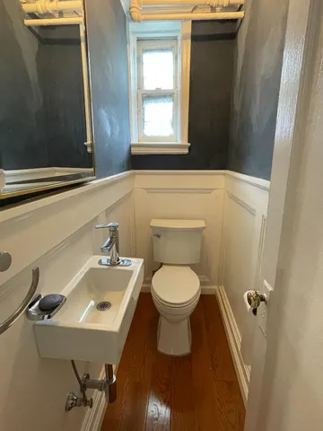 a bathroom with a toilet sink and mirror