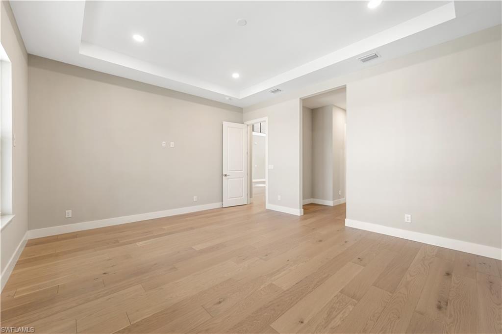 9127 Wisteria Way Naples, FL 34114 - Photo 18 of 50 an empty room with wooden floor and windows