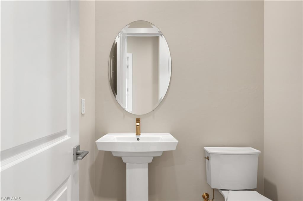 9127 Wisteria Way Naples, FL 34114 - Photo 28 of 50 a bathroom with a toilet sink and mirror