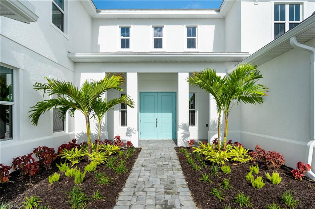 9127 Wisteria Way Naples, FL 34114 - Photo 39 of 50 a vase with flowers on the side of a house