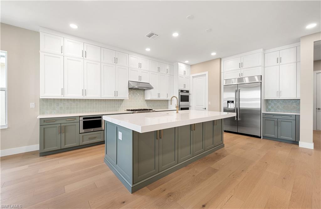 9127 Wisteria Way Naples, FL 34114 - Photo 4 of 50 a kitchen with kitchen island cabinets and oven