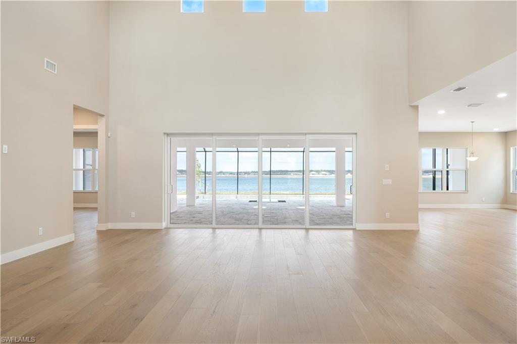 9127 Wisteria Way Naples, FL 34114 - Photo 9 of 50 wooden floor in an empty room with a window