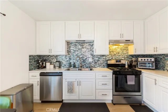 a kitchen with white cabinets and white appliances
