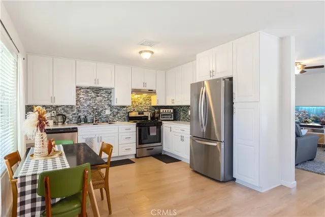 a kitchen with kitchen island refrigerator stove microwave and chair