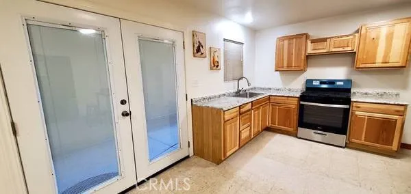 a kitchen with stainless steel appliances granite countertop a stove a sink and a refrigerator