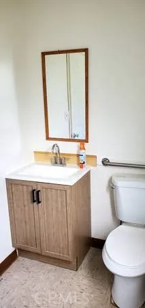 a bathroom with a sink mirror vanity and toilet