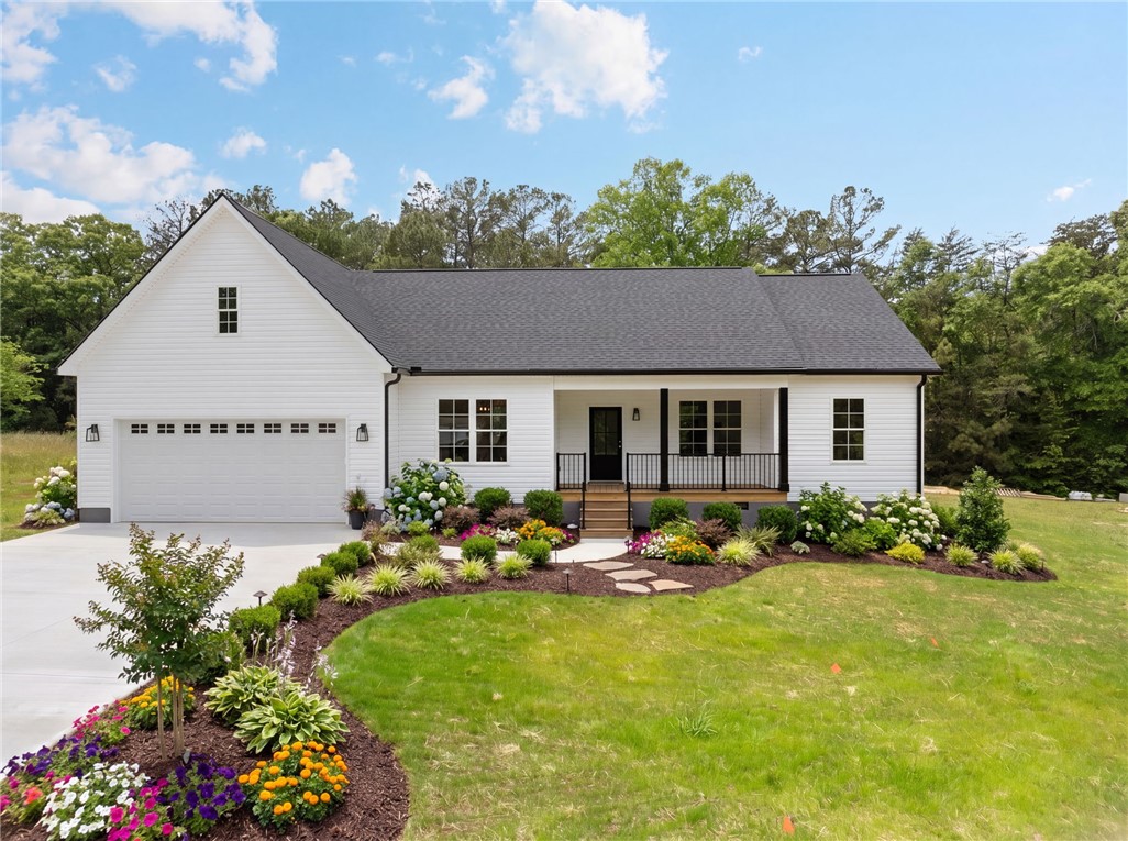1735 Maw Bridge Road Central, SC 29630 - Photo 2 of 42 White siding and a dark roof define this new construction, complemented by vibrant landscaping leading to the inviting front porch.