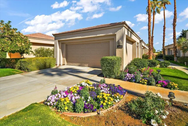 a front view of a house with a yard and potted plants