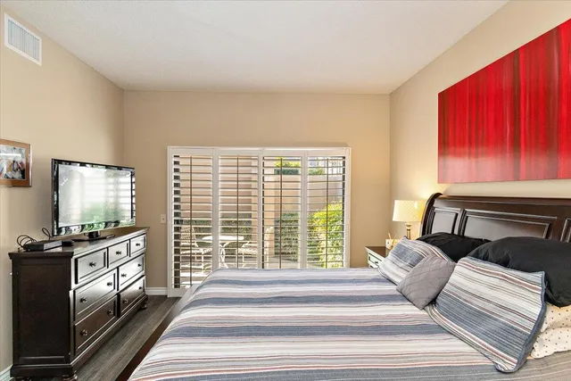 a spacious bedroom with a bed and wooden floor