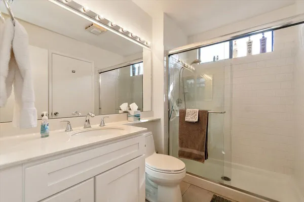 a bathroom with a sink a mirror a toilet and shower