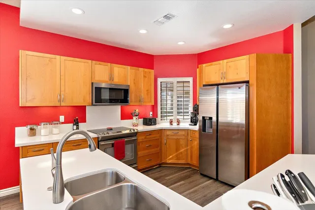 a kitchen with stainless steel appliances granite countertop a refrigerator and a stove