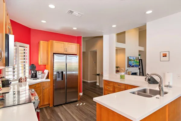 a kitchen with stainless steel appliances granite countertop a sink and a refrigerator
