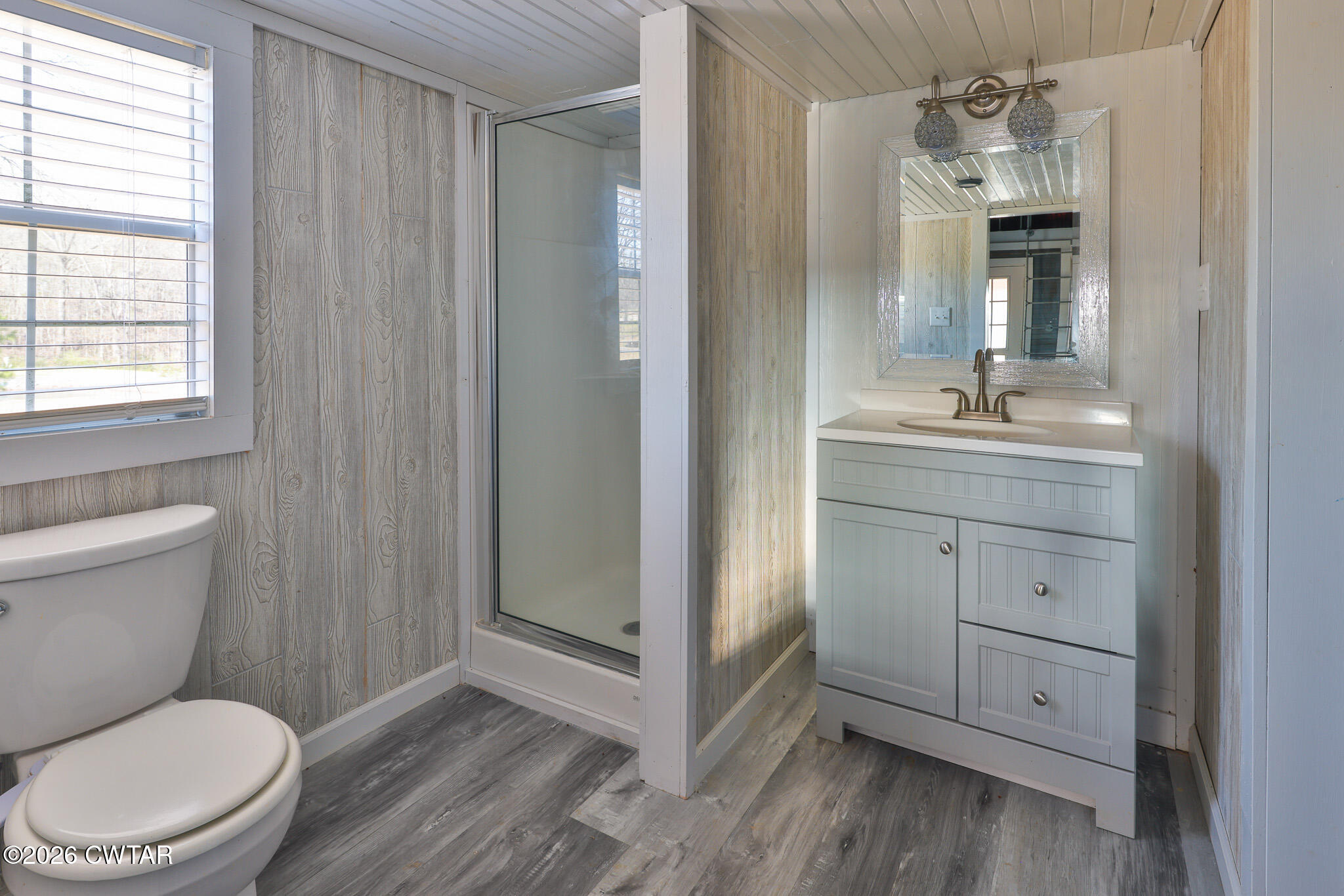 295 Adams Road Greenfield, TN 38230 - Photo 21 of 35 a bathroom with a toilet a sink a mirror a vanity and window