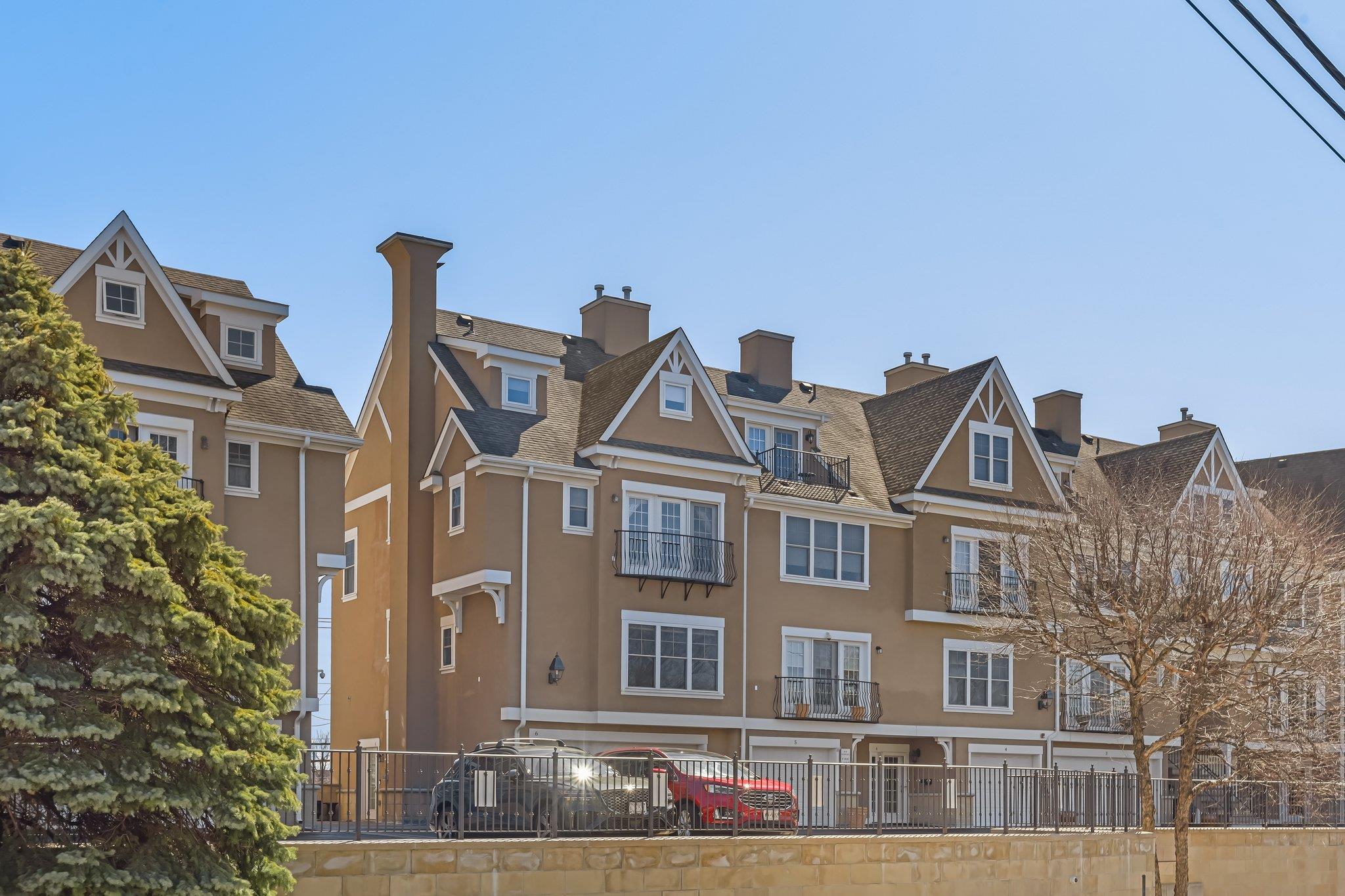 80 Old Boston Post Road, Unit 6 New Rochelle, NY 10801 - Photo 1 of 1 View of front facade featuring stucco siding, a residential view, a chimney, and fence