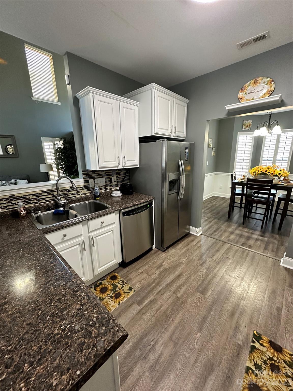 109 Windstone Drive Troutman, NC 28166 - Photo 4 of 22 a kitchen with stainless steel appliances a refrigerator a stove a sink a dining table and chairs