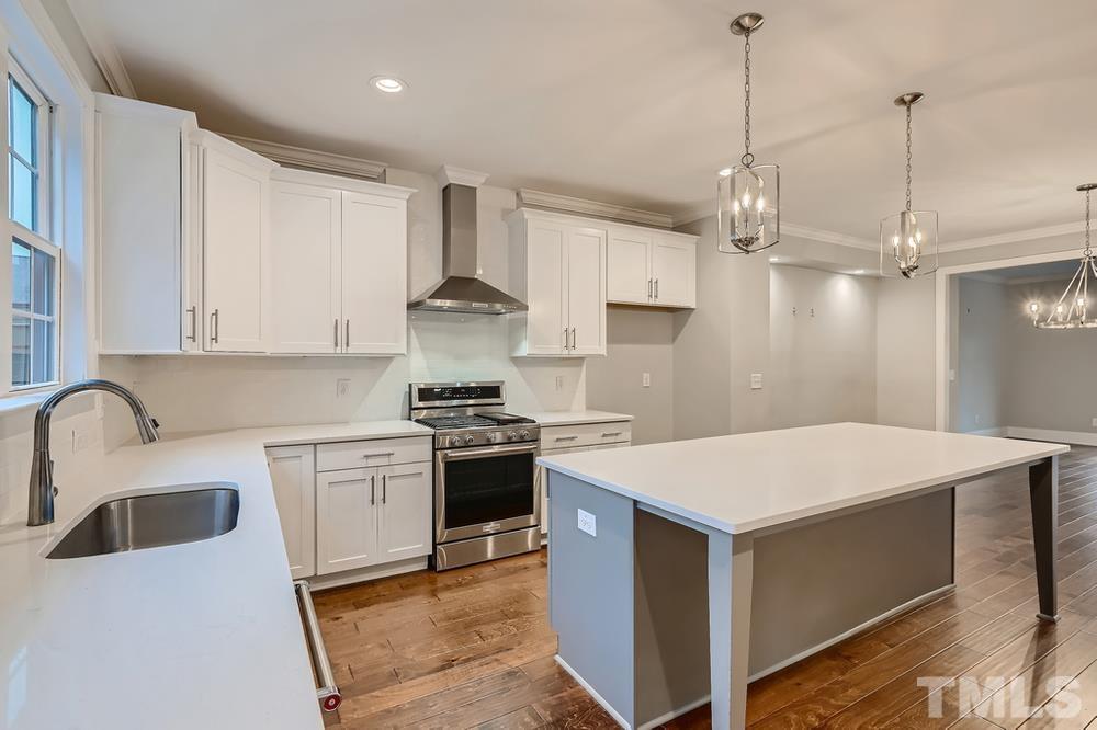 1604 Bowery Drive Raleigh, NC 27607 - Photo 11 of 28 a kitchen that has a sink a stove and a table with chairs