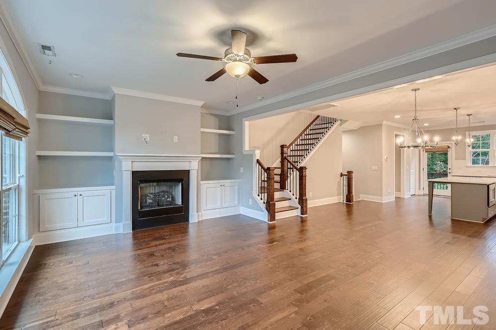 1604 Bowery Drive Raleigh, NC 27607 - Photo 6 of 28 a view of an empty room with wooden floor fireplace and a window