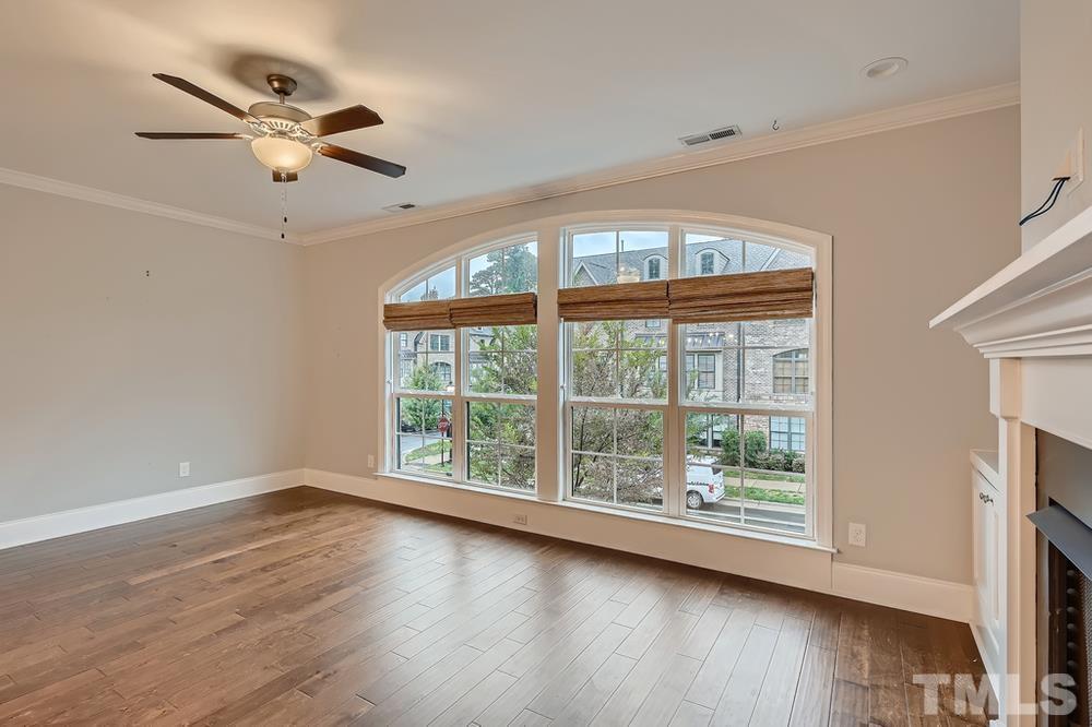 1604 Bowery Drive Raleigh, NC 27607 - Photo 7 of 28 an empty room with wooden floor fan and windows