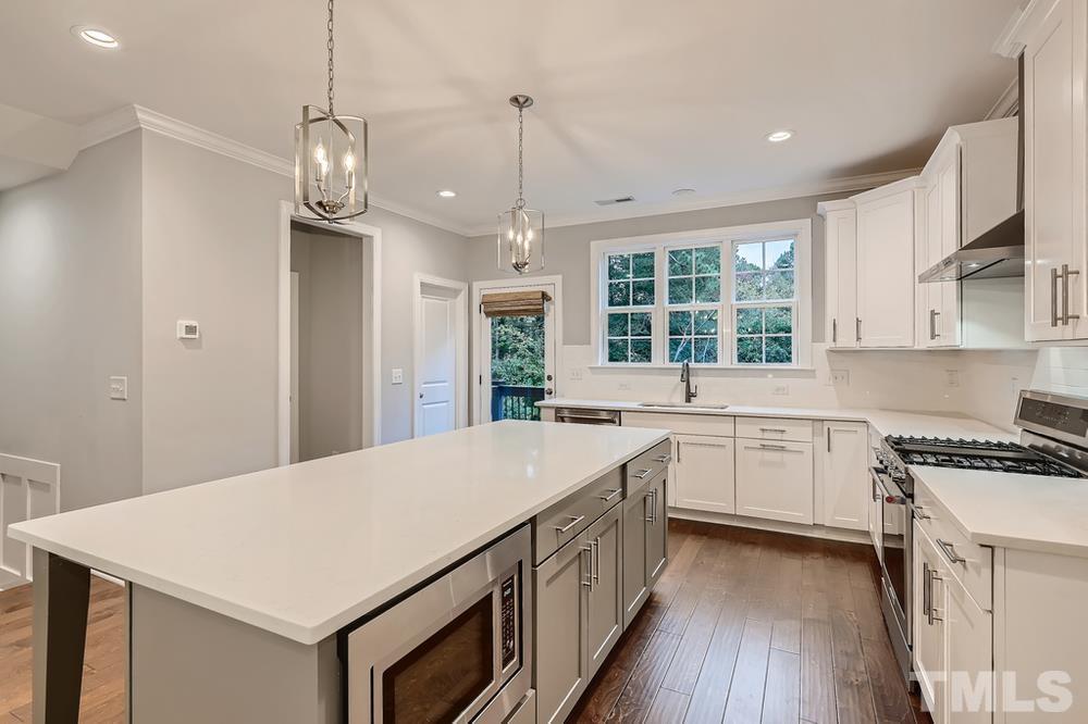 1604 Bowery Drive Raleigh, NC 27607 - Photo 9 of 28 a kitchen with a stove a sink and a refrigerator