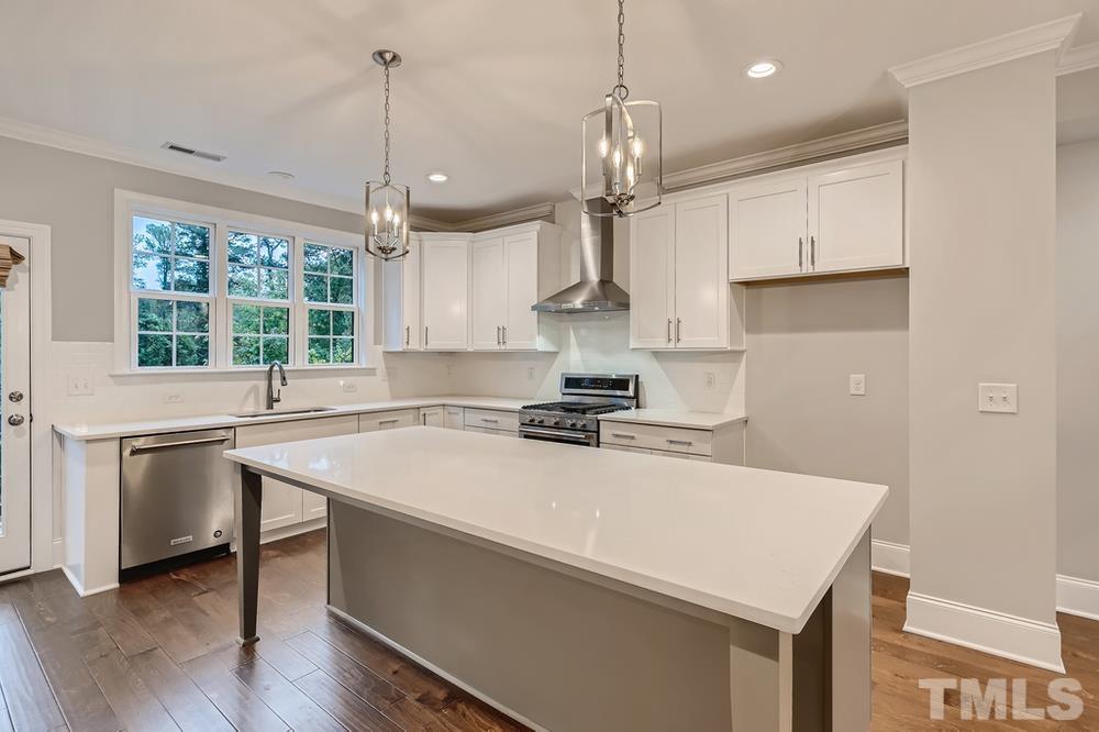 1604 Bowery Drive Raleigh, NC 27607 - Photo 10 of 28 a kitchen with a stove a sink a center island and windows