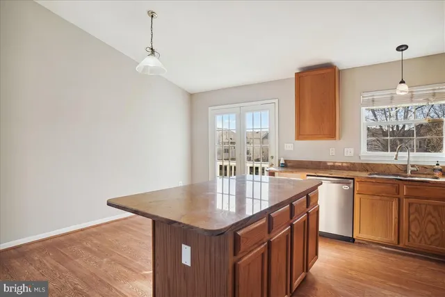 a kitchen with stainless steel appliances granite countertop a sink a stove and a wooden floors