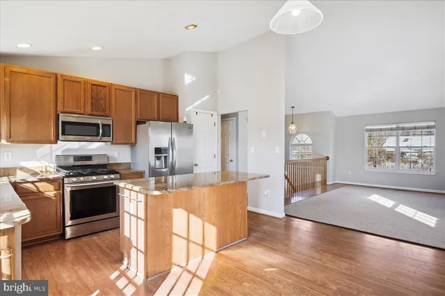 a large kitchen with cabinets wooden floor and stainless steel appliances