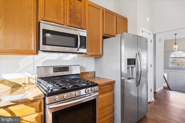 a kitchen with stainless steel appliances granite countertop a stove microwave and refrigerator